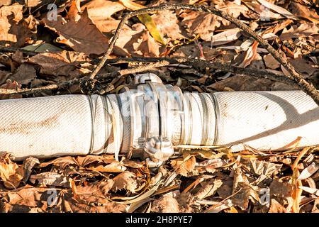 Anschluss von Rohren zum Pumpen von Wasser aus dem Teich mit einer Kupplung und einem Draht. Im Laufe der Zeit rostet der Draht und die Rohre laufen aus. Stockfoto