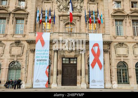 Marseille, Frankreich. 01st Dez 2021. Im Rahmen des Welt-Aids-Tages, der jährlich am 1. Dezember gefeiert wird, ist der Welt-Aids-Tag eine Gelegenheit für Menschen auf der ganzen Welt, sich im Kampf gegen HIV zu vereinen, und zwar mit Spruchbändern mit roten Ribbons (anerkannte Symbole für AIDS-Bewusstsein) auf der façade des Rathauses von Marseille. Unterstützung für Menschen mit HIV/AIDS zeigen und vereint sein. Das rote Band ist ein internationales Symbol, das wir an unsere Kleidung hängen, um unsere Solidarität mit den Opfern von HIV und AIDS zu zeigen. Kredit: SOPA Images Limited/Alamy Live Nachrichten Stockfoto