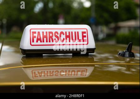 Schild einer Fahrschule auf dem Dach eines Trainingsfahrzeugs. Die Buchstaben 'FAHRSCHULE' bedeuten 'Fahrschule' Stockfoto