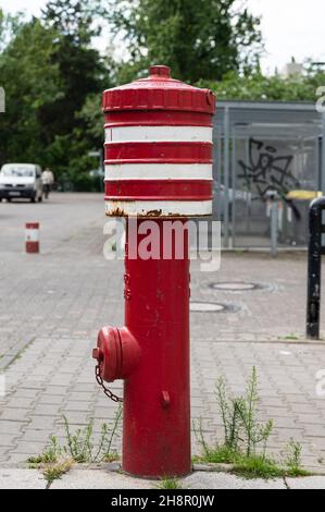 Rot-weiß lackierter Hydrant in einem Wohngebiet Stockfoto
