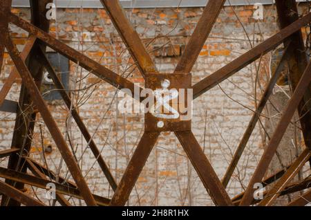 Rostige Metallstruktur auf Backsteinwand Hintergrund. Nummer acht. Abstrakter rostiger Hintergrund. Prozess-Alterung von alten Eisenbauten Stockfoto