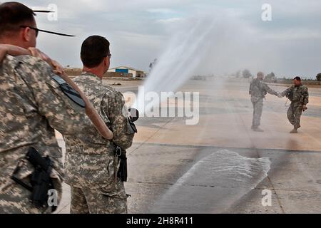 Gemäß der Luftfahrttradition, Chief Warrant Officers Dan Wallace (Hintergrund rechts), aus Fort Hood, Texas, der taktische Offizier der Brigade, Und Donald Washabaugh aus Collingswood, N.J., dem Wartungsbeauftragten der Brigade für die Luftfahrt, schüttelt die Hände, während er am 25. März von den Kollegen der Flieger, den Chief Warrant Officers Michael Reese (vorne rechts), aus Copperas Cove, Texas, dem Instruktor für Brigadenstandardisierungen, und Scott McLendon, ebenfalls aus Copperas Cove, dem Sicherheitsbeauftragten der Brigade, beschmiert wurde. Alle befinden sich in der 1st Air Cavalry Brigade, 1st Cavalry Division, U.S. Division-Center. Wallace A Stockfoto