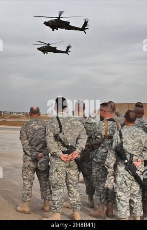 Der Chief Warrant Officer 5 Dan Wallace aus Fort Hood, Texas, war auf ihrem letzten Flug als Kommandant-Piloten der taktische Einsatzoffizier der Brigade, Und Chief Warrant Officer 5 Donald Washabaugh, aus Collingswood, N.J., der Brigade Aviation Maintenance Officer, beide AH-64D Apache greifen Hubschrauberpiloten in der 1st Air Cavalry Brigade, 1st Cavalry Division, U.S. Division-Center an, machen einen Überkopfpass vor Soldaten, die ihren Dienst als Flieger am 25. März ehren. Die Soldaten warteten auf die Landungen der Flieger und gratulierten ihnen zum letzten Flug. Stockfoto