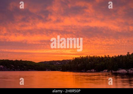 Spiegelungen des Sonnenuntergangs am Himmel im George Lake, Killarney Provincial Park, Killarney, Ontario, Kanada Stockfoto