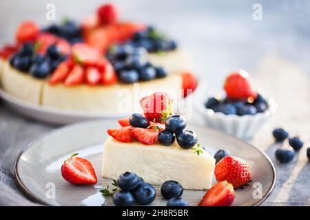 Vanilla New York Käsekuchen mit frischen Heidelbeeren und Erdbeeren dekoriert Stockfoto