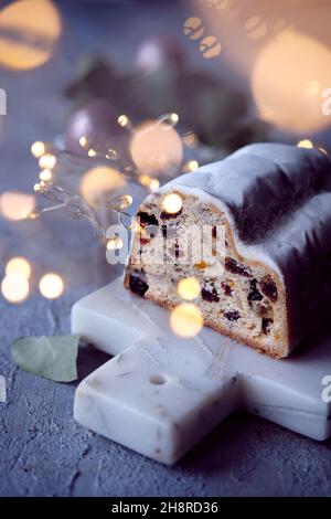 Weihnachtsstollen auf blaugrünem festlichem Hintergrund mit Girlande, Weihnachtsbeleuchtung. Stockfoto