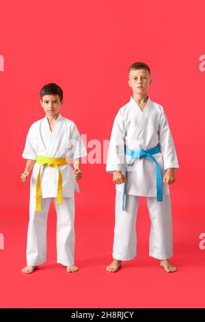 Kleine Jungen in Karategi auf farbigem Hintergrund Stockfoto