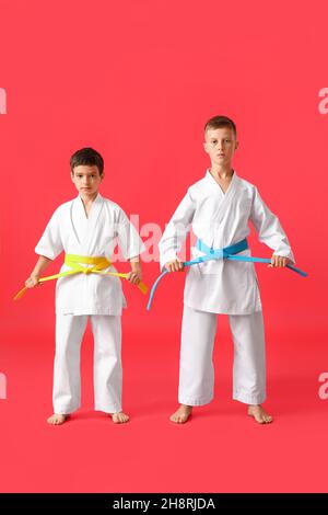 Kleine Jungen in Karategi auf farbigem Hintergrund Stockfoto