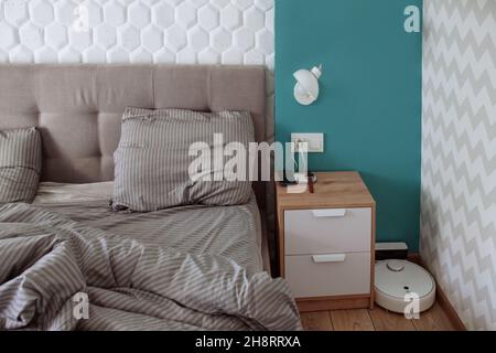 Innen von weißen und grauen gemütlichen Schlafzimmer .Robot Staubsauger Stockfoto