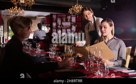 Freundlich lächelnd weibliche Kellner bringen um Besucher im luxuriösen Restaurant Stockfoto