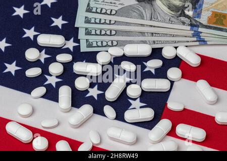 Verschreibungspflichtige Medikamente Pillen und 100-Dollar-Scheine auf amerikanischer Flagge. Pharmaindustrie, Importe und Exporte sowie Kosten für die Opiod Painkiller-sucht Stockfoto