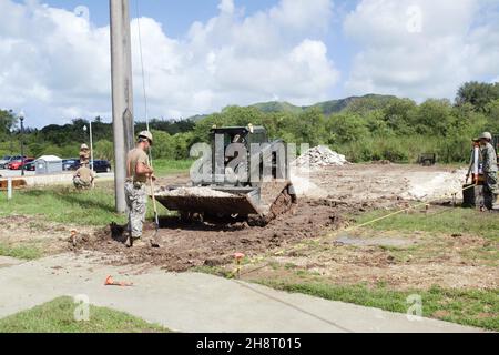 201124-N-DW186-1002 SANTA RITA, Guam (Nov 24, 2021) Seabäer der US-Marine, die dem Naval Mobile Construction Bataillon (NMCB) 5 zugewiesen wurden, graben Asphalt, bevor sie an Bord des Marinestützpunkts Guam eine Betonunterlage aufstellen. Die Seabees der US-Marine, die NMCB-5 zugewiesen sind, werden in den Einsatzbereich der US-Flotte 7th eingesetzt, um einen freien und offenen Indo-Pazifik-Raum zu unterstützen, ihre Allianzen und Partnerschaften zu stärken und gemeinsame Einsatzkräfte mit allgemeiner ingenieurtechnischer und ziviler Unterstützung zu unterstützen. Der NMCB-5, der von Port Hueneme (Kalifornien) aus beheimatet ist, verfügt über 13 detaillierte Standorte, die im gesamten US-amerikanischen und im indopazifischen Raum eingesetzt werden Stockfoto