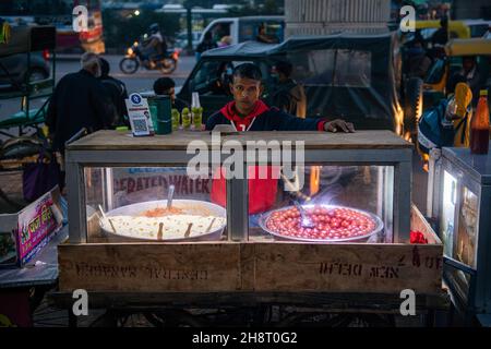 Ghaziabad, Indien. 01st Dez 2021. Indischer Straßenverkäufer sah, wie er in der Nähe des Anand vihar-Busterminals indische Süßigkeiten verkaufte.im Jahr 2020-21 wurde das Straßenverkaufgeschäft durch das Coronavirus schwer getroffen. Kredit: SOPA Images Limited/Alamy Live Nachrichten Stockfoto