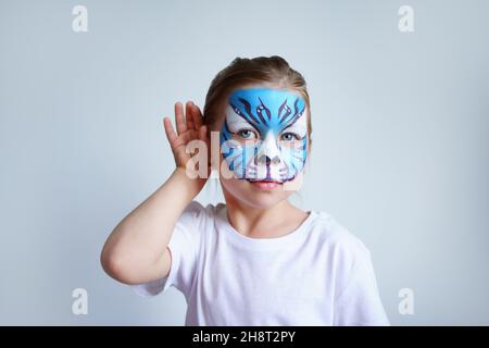 Mädchen Aqua Make-up in Form eines blauen Wassertiger Tierkreises auf weißem Hintergrund, Konzeptsymbol des neuen Jahres 2022, hört ein Porträt Stockfoto