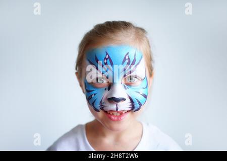 Mädchen Aqua Make-up in Form eines blauen Wassertiger Tierkreises auf weißem Hintergrund, Konzeptsymbol des neuen Jahres 2022, Lächeln Porträt Stockfoto