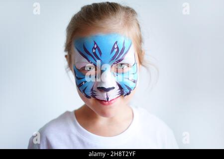 Mädchen Aqua Make-up in Form eines blauen Wassertiger Tierkreises auf weißem Hintergrund, Konzeptsymbol des neuen Jahres 2022, Lächeln Porträt Stockfoto