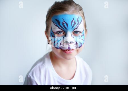 Mädchen Aqua Make-up in Form eines blauen Wassertiger Tierkreises auf weißem Hintergrund, Konzeptsymbol des neuen Jahres 2022, Lächeln Porträt Stockfoto