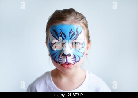 Mädchen Aqua Make-up in Form eines blauen Wassertiger Tierkreises auf weißem Hintergrund, Konzeptsymbol des neuen Jahres 2022, trauriges Porträt Stockfoto