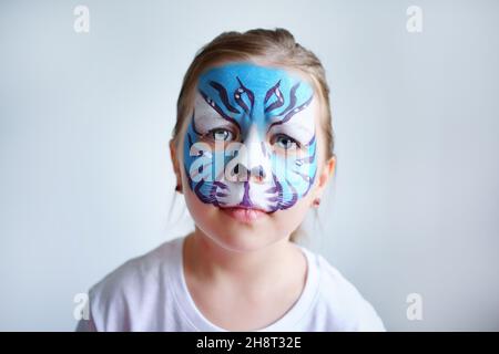 Mädchen Aqua Make-up in Form eines blauen Wassertiger Tierkreises auf weißem Hintergrund, Konzeptsymbol des neuen Jahres 2022, trauriges Porträt Stockfoto