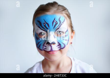 Mädchen Aqua Make-up in Form eines blauen Wassertiger Tierkreises auf weißem Hintergrund, Konzeptsymbol des neuen Jahres 2022, Lächeln Porträt Stockfoto