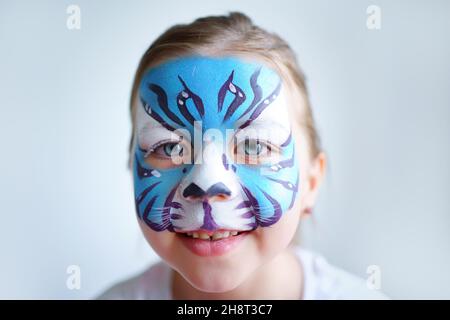 Mädchen Aqua Make-up in Form eines blauen Wassertiger Tierkreises auf weißem Hintergrund, Konzeptsymbol des neuen Jahres 2022, Lächeln Porträt Stockfoto