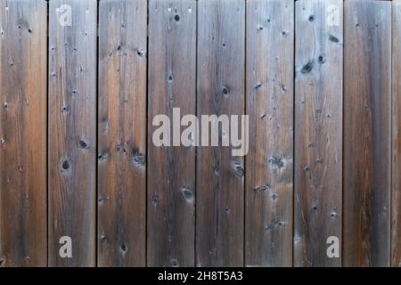 Verwitterte vertikale Decksbretter, mit Knoten. Grau-orange-braune Farbtöne Stockfoto