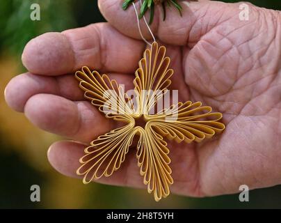 01. Dezember 2021, Brandenburg, Senftenberg: Handgefertigte Weihnachtsschmuck der Frauen des Fördervereins Museum des Landkreises Oberspreewald-Lausitz hängen im Museum von Schloss Senftenberg an einem Weihnachtsbaum. Nach einem Jahr Pause leuchten ab kommenden Samstag, 04. Dezember 2021, wieder über 40 festlich geschmückte Weihnachtsbäume im Schloss- und Festungsmuseum Senftenberg. Rot und Gold, Blau und Weiß oder ganz in Lila – helle Farben stehen im Mittelpunkt der diesjährigen Ausstellung. Kugeln, Ketten, Sterne und Anhänger werden mit handgefertigten Einzelstücken kombiniert. Gehäkelte Trolle, r Stockfoto