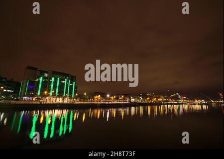 Schöne Weitwinkel-Abendansicht des Flusses Liffey mit Gebäuden und Sehenswürdigkeiten und Lichtreflexionen im Wasser, Dublin, Irland Stockfoto