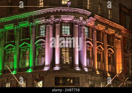 Dublin, Irland - 13. November 2021: Wunderschöne Abendansicht von Projektionslichtern, die an der Fassade der Grand Central Bar die irische Flagge imitieren Stockfoto