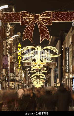 Dublin, Irland - 13. November 2021: Wunderschöne Aussicht auf festliche Weihnachtslichter und den dekorierten Arnotts-Laden in der geschäftigen Henry Street während der COVID-19 Stockfoto