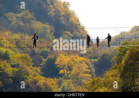 Touristen auf der Hängebrücke über den Fluss Stockfoto