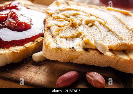 Nahaufnahme aus der Nähe von Erdnussbutter und Marmelade-Sandwiches auf Schneidebrett. Gesunde Ernährung Konzept Stockfoto