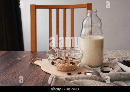 Haferflocken, Milch und Trockenobst auf dem Tisch Stockfoto