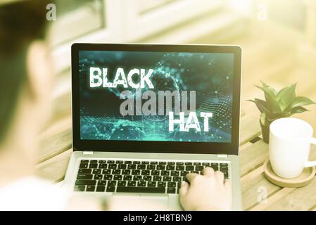 Inspiration mit Schild Black hat. Konzept Bedeutung in Bezug auf eine schlechte Person verwendet, vor allem ein Bösewicht oder kriminelle Frau tippen auf Laptop neben Stockfoto