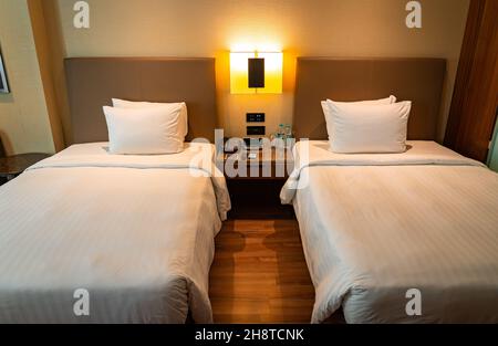 Ein Deluxe-Hotelzimmer mit zwei luxuriösen Twin-Betten bietet Platz und Komfort für Geschäfts- und Urlaubsreisende. Stockfoto