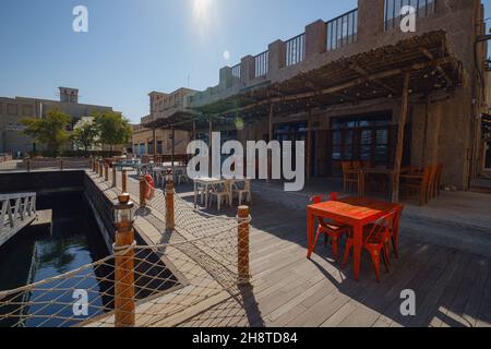 Dubai, VAE 17. Februar 2020: Alte Gebäude in Dubai und arabische Straße. Historisches Al Fahidi Viertel, Al Bastakiya. Heritage District in Vereinigte Arabische Emirate. Restaurant auf dem Pier Stockfoto