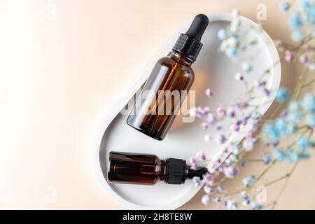 Draufsicht auf zwei Pipettenflaschen aus dunklem Glas mit ätherischem Öl und Kollagen für die Hautpflege. Paket ohne Branding mit Kopierplatz. Designer-Mokup. Stockfoto