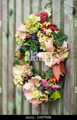 Farbenfroher Herbstkranz an einem Gartenzaun Stockfoto