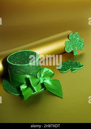 Grüner Hut mit goldenen Münzen und Kleeblatt auf Goldtisch, st patricks Tageskonzept. Stockfoto