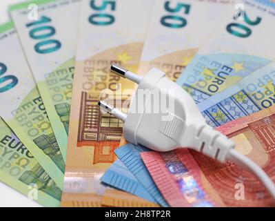 Weißer Stecker auf Euro-Banknoten, Konzept der Strompreiserhöhung Stockfoto