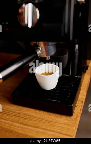 Tasse Kaffee, der mit einer Espressomaschine in Einem Café zubereitet wird, Kaffeemaschine, die Espresso-Kaffee herstellt Stockfoto