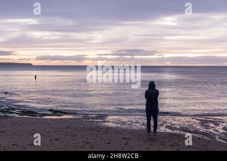 Myrtleville, Cork, Irland. 02nd. Dezember 2021. Ronan Collins aus Bandon wartet auf den Sonnenaufgang am Myrtleville Beach, Co. Cork, Irland. - Credit; David Creedon / Alamy Live News Stockfoto