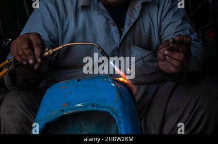 Während die Straßen Pakistans mit billigen chinesischen Motorrädern übersät sind, sind die Liebhaber des seltenen Vespa-Motorrollers auf der Suche nach dem Ersatz-pak Stockfoto