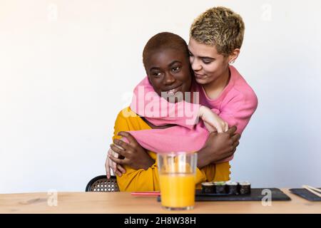 Nahaufnahme eines Porträts verschiedenster, glücklicher und bester Freunde aus verschiedenen Rassen, die sich umarmen und in der Halle lachen Stockfoto