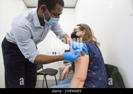 London, Großbritannien, 2. Dezember 2021: Helen Eastman, 42, erhält ihren Pfizer-Booster-Jab im Pop-up-Impfzentrum von Pearl Chemists in Tooting, Süd-London. Die Regierung hat versprochen, allen Erwachsenen bis Ende Januar 2022 eine dritte Impfdosis anzubieten, da befürchtet wird, dass sich das omicron-Varant schnell ausbreiten könnte, sobald es in Großbritannien mit der Übertragung in die Gemeinschaft beginnt. Anna Watson/Alamy Live News Stockfoto