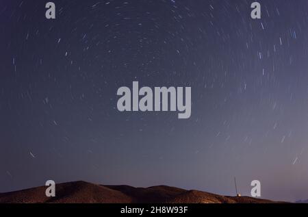 Nachtansicht von einem Hügel in der Wüste mit Sternspuren und Nordstern im Rahmen im iran Stockfoto