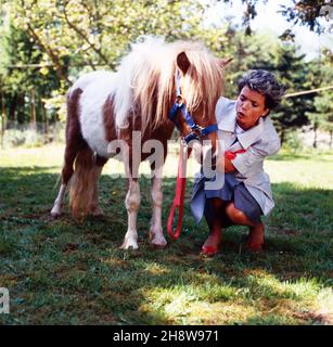 Uschi Glas, deutsche Schauspielerin, mit Pony bei den Dreharbeiten zur ZDF Vorabendserie 'der Landarzt', Deutschland 1987. Die deutsche Schauspielerin Uschi Glas und ein Pony während der Produktion der deutschen Fernsehserie 'der Landarzt', Deutschland 1987. Stockfoto