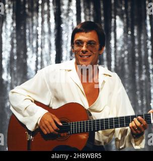 Reinhard Mey, deutscher Liedermacher, bei einem Auftritt in der Wettshow 'Wetten, dass', Deutschland 1983. Der deutsche Songwriter Reinhard Mey tritt bei der TV-Show 'Wetten, dass', Deutschland 1983 auf. Stockfoto