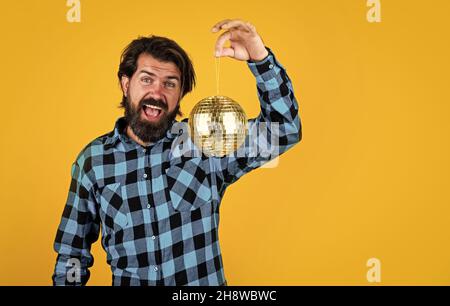 Casual Mann hält leuchtenden Disco Ball. Lustige und fröhliche Mann mit Spaß auf der Party. Zeit für Spaß. Bärtige Hipster bereit, den Urlaub zu feiern. Urlaub Stockfoto