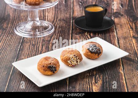 Bombolon oder Bomboloni ist ein italienisches gefülltes Donut- und Snackfutter. Deutsche Krapfen - Krapfen oder berliner - gefüllt mit Marmelade und Schokolade Stockfoto